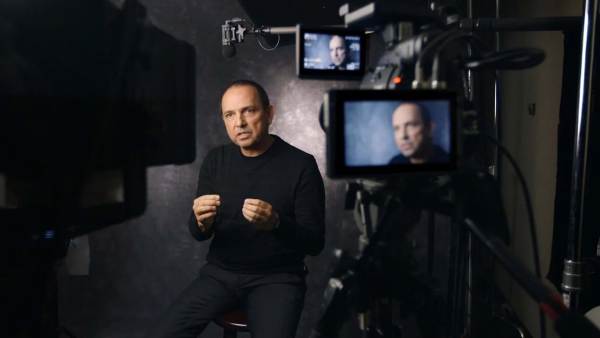 Teddy Crus sitting on a film set in front of multiple cameras with his face displayed on all monitors.